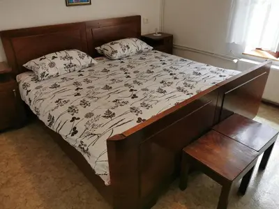 a bedroom with a bed with a wooden bed frame at Idina domačija in Trenta