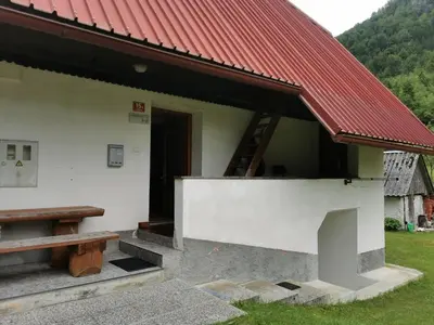 a building with a red roof and a bench at Idina domačija in Trenta