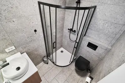 a bathroom with a shower and a sink at Blue Alpine Nest in Komenda