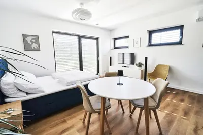 a room with a bed and a table and chairs at Blue Alpine Nest in Komenda