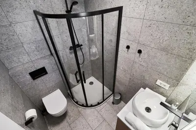 a bathroom with a shower and a toilet and a sink at Green Alpine Nest in Komenda