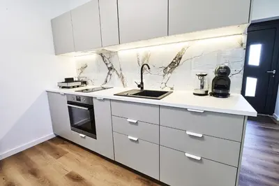 a kitchen with white cabinets and a sink at Green Alpine Nest in Komenda