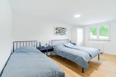 a bedroom with two beds and a desk and a window at Apartment SočaFly in Tolmin