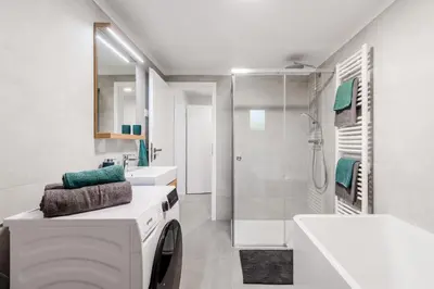a white bathroom with a washing machine in it at Apartment SočaFly in Tolmin