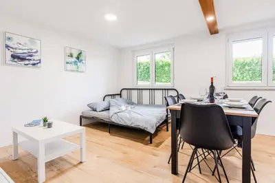 a living room with a table and a bed at Apartment SočaFly in Tolmin