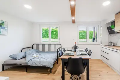 a kitchen and dining room with a bed and a table at Apartment SočaFly in Tolmin
