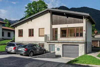 two cars parked in front of a house at Apartment SočaFly in Tolmin