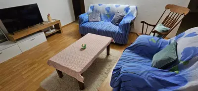 a living room with a couch a chair and a tv at Cozy ap rooms 2nd floor near Capital of Slovenia in Ljubljana