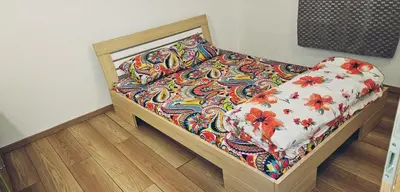 a bed in a room with a floral comforter at Cozy ap rooms 2nd floor near Capital of Slovenia in Ljubljana