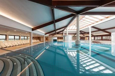 a large indoor swimming pool with chairs at Mobile House LaSiesta Thermal park Terme 3000 in Moravske Toplice