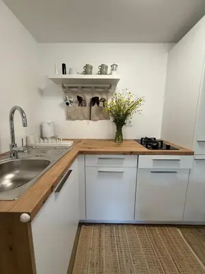 a kitchen with white cabinets and a vase of flowers at Mobile House LaSiesta Thermal park Terme 3000 in Moravske Toplice