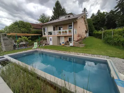 a villa with a swimming pool in front of a house at Sunny Karla apartment Dramlje in Dramlje