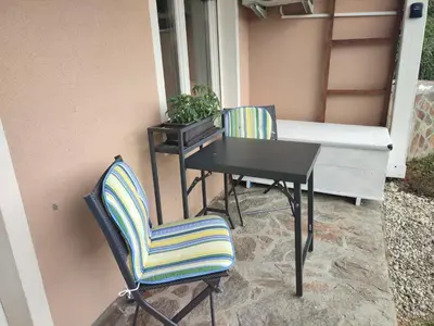 two chairs and a table and a table and a desk at Sunny Karla apartment Dramlje in Dramlje