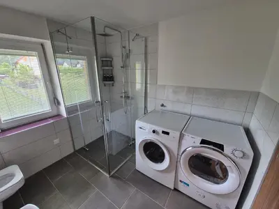 a bathroom with a washing machine and a shower at Vila Jelena Gorje, Vintgar, Bled in Zgornje Gorje