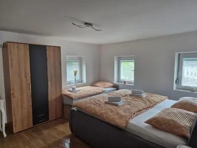 a bedroom with two beds and two windows at Vila Jelena Gorje, Vintgar, Bled in Zgornje Gorje