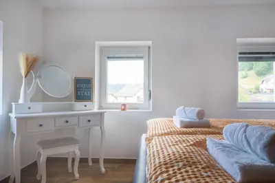 a bedroom with a bed and a dressing table and a mirror at Vila Jelena Gorje, Vintgar, Bled in Zgornje Gorje