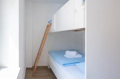 a room with a bunk bed with a ladder and towels at Vila Jelena Gorje, Vintgar, Bled in Zgornje Gorje