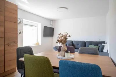 a dining room with a table with chairs and a couch at Vila Jelena Gorje, Vintgar, Bled in Zgornje Gorje