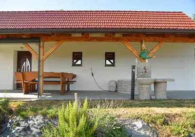 a pavilion with a table and a bench in front of a building at Gold Wine Estate in Podlehnik