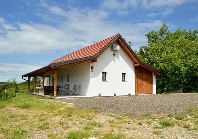a small white house with a red roof at Gold Wine Estate in Podlehnik