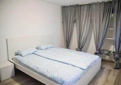 a bedroom with a bed with blue sheets and curtains at Gold Wine Estate in Podlehnik