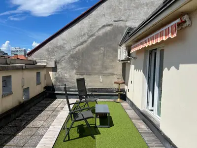 a patio with a chair and a table on a balcony at Tabor in Ljubljana