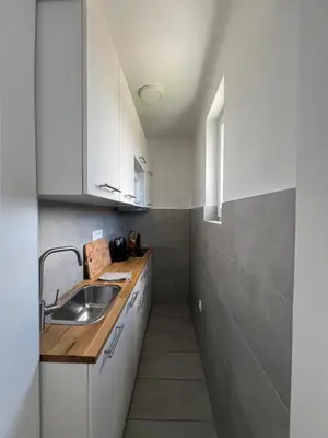 a small kitchen with white cabinets and a sink at Tabor in Ljubljana