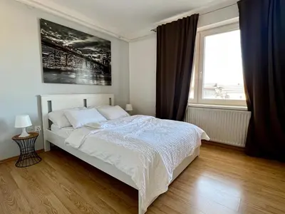 a bedroom with a white bed and a window at Tabor in Ljubljana