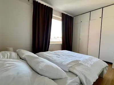 a white bed in a bedroom with a window at Tabor in Ljubljana