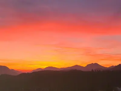 a painting of a sunset over mountains at Apartma Angelika in Mozirje