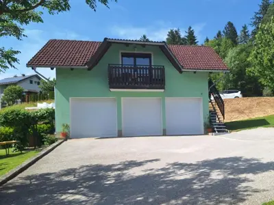 a house with two garage doors in a driveway at Apartma Angelika in Mozirje