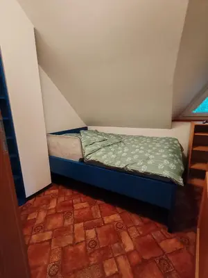 a small bed sitting in a small room at apartma Pohorc - Kostanj in Pohorje