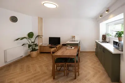 a kitchen with a wooden table and a dining room at K&M apartments Bled in Bled