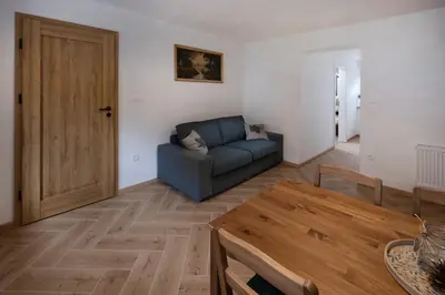 a living room with a blue couch and a table at K&M apartments Bled in Bled
