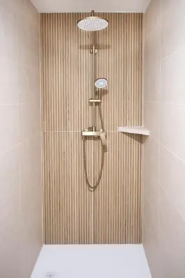 a shower with a shower head in a bathroom at K&M apartments Bled in Bled