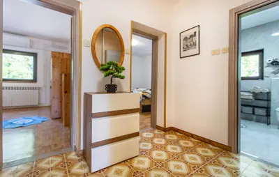 a hallway with a mirror and a dresser with a plant at 4 Bedroom Beautiful Home In Sezana in Sežana