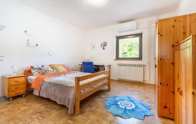 a bedroom with a bed with a blue flower on the floor at 4 Bedroom Beautiful Home In Sezana in Sežana