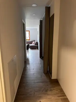 a hallway with a room with a couch and a table at U Izi 2 in Kranjska Gora