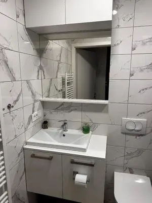 a white bathroom with a sink and a mirror at U Izi 2 in Kranjska Gora
