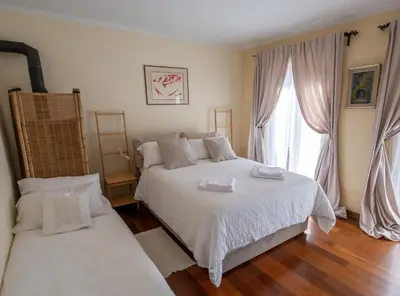a bedroom with two beds and a large window at Hiša pri poetu in Šempeter pri Gorici