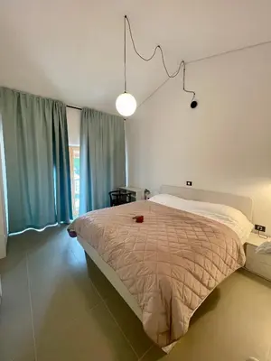 a bedroom with a large bed and a lamp at Studio Vila Olga in Dutovlje