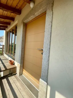 a brown garage door on a house with a porch at Studio Vila Olga in Dutovlje