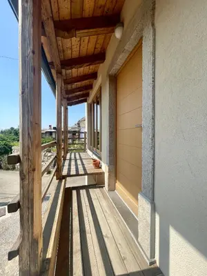 a wooden porch of a house with a door at Studio Vila Olga in Dutovlje