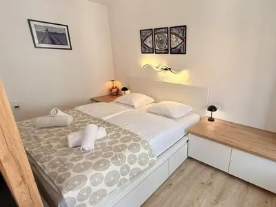 a bedroom with a large bed with two pillows at Apartments KrAnJ - City Studio Katka in Kranj