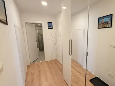 a hallway with white walls and a glass door at Apartments KrAnJ - City Studio Katka in Kranj