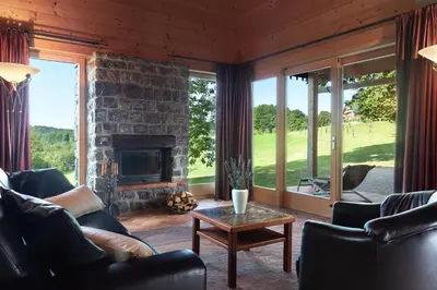 a living room with a stone fireplace and a table at Posestvo Pule Equestrian Estate in Trebelno