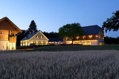 a barn and a house with a field of grass at Posestvo Pule Equestrian Estate in Trebelno