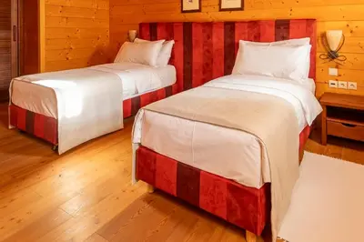 two beds in a room with wooden floors at Posestvo Pule Equestrian Estate in Trebelno