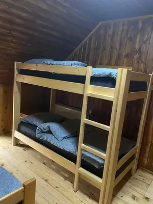 two bunk beds in a room with wooden walls at Koča na Kranjski dolini Krnica 93 a,Pokljuka in Zgornje Gorje