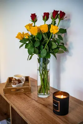 a vase of flowers sitting on a table with a candle at Apartma pod macesnom in Jesenice